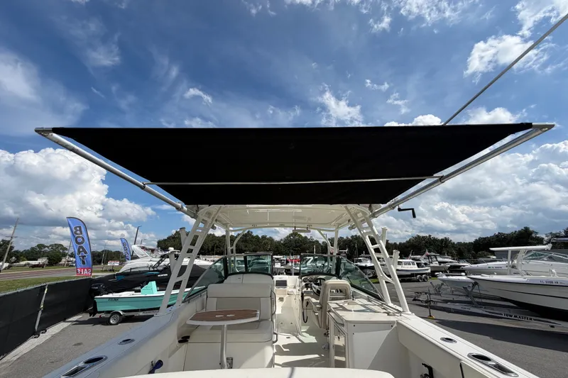 Slide: The Image of 2015 Boston Whaler 270 Vantage boat with canopy, displayed at a boat sale event. - 16
