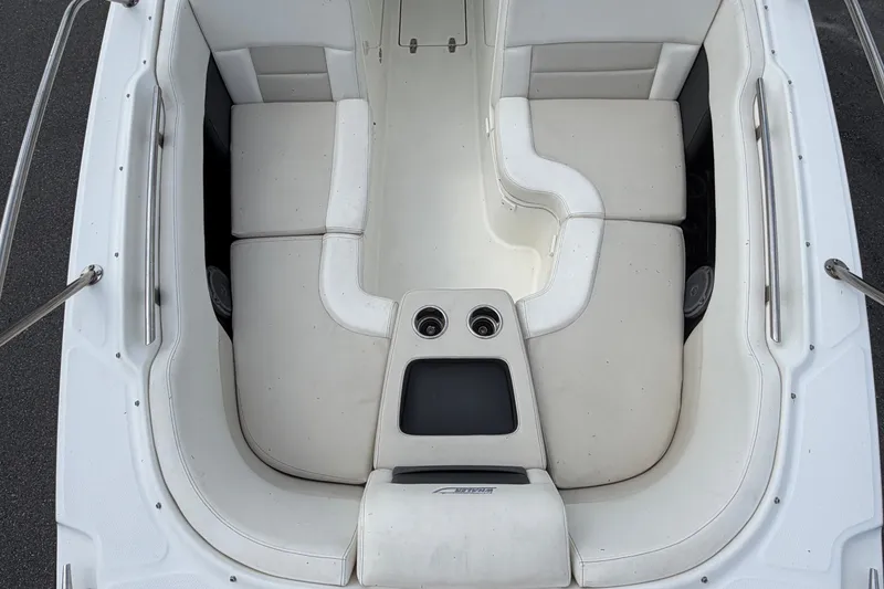 Slide: The Image of 2015 Boston Whaler 270 Vantage boat interior with white cushioned seating and cup holders. - 53