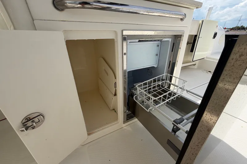 Slide: The Image of Boston Whaler 270 Vantage 2015 boat storage compartments and pull-out drawer. - 22
