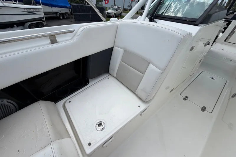 Slide: The Image of 2015 Boston Whaler 270 Vantage interior seating with storage compartment, showcasing white upholstery. - 55
