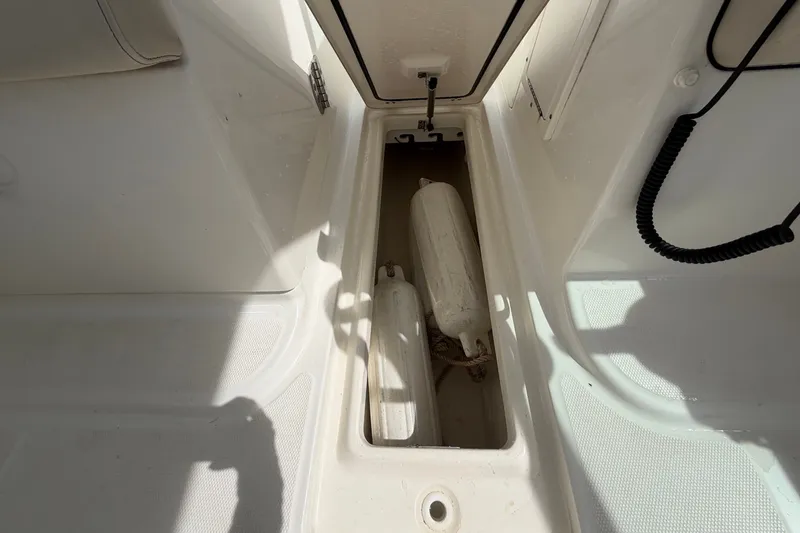 Slide: The Image of Storage compartment on a 2015 Boston Whaler 270 Vantage boat, featuring safety equipment. - 25