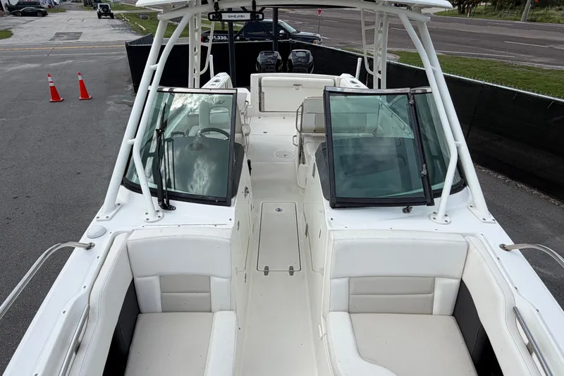 Slide: The Image of 2015 Boston Whaler 270 Vantage boat interior with seating and windshield, docked on pavement. - 54