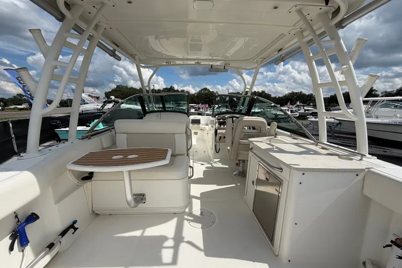 Slide: The Image of 2015 Boston Whaler 270 Vantage boat interior with seating, table, and helm under a clear sky. - 17