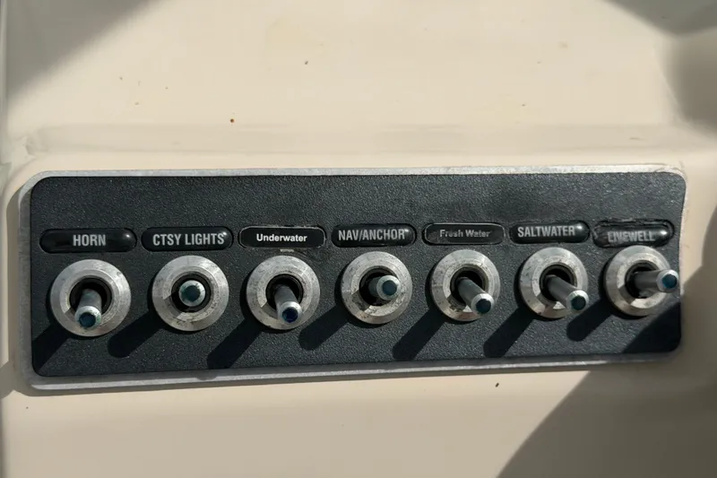 Slide: The Image of Control panel of a 2015 Boston Whaler 270 Vantage boat with labeled switches. - 42