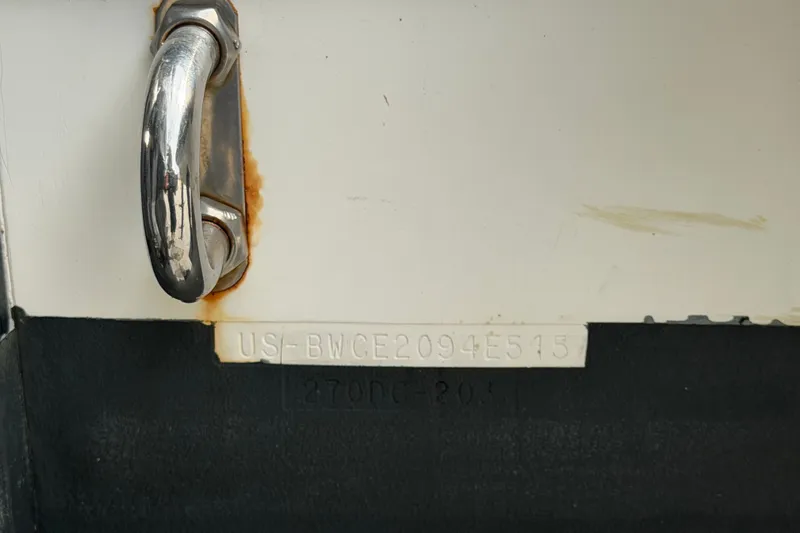 Slide: The Image of 2015 Boston Whaler 270 Vantage boat hull identification number and metal handle detail. - 77