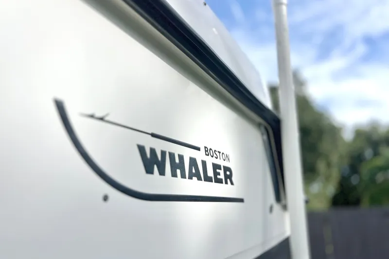 Slide: The Image of 2015 Boston Whaler 270 Vantage boat logo with blurred outdoor background. - 25