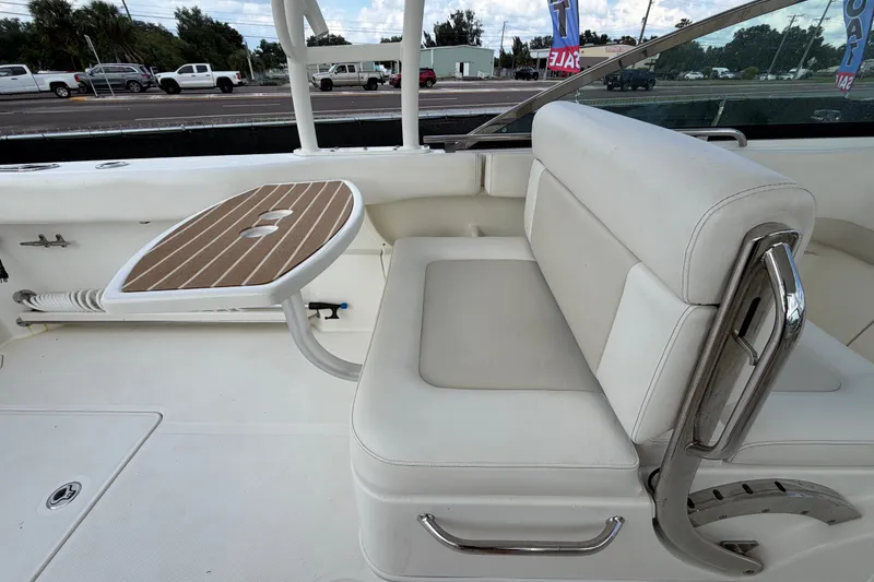 Slide: The Image of 2015 Boston Whaler 270 Vantage interior with white seating and wooden table. - 65