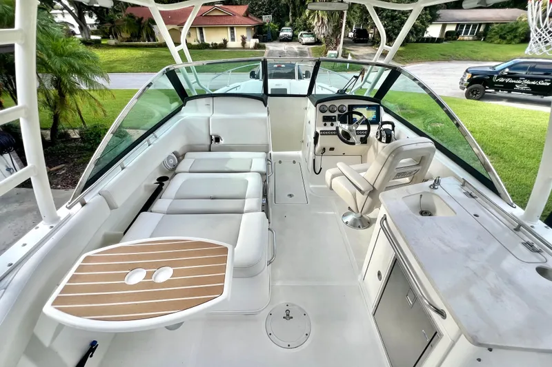 Slide: The Image of 2015 Boston Whaler 270 Vantage boat interior with seating, helm, and kitchenette. - 96