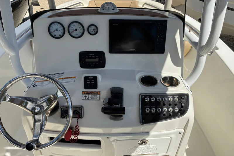 Slide: The Image of 2019 NauticStar 2102 Legacy boat dashboard with steering wheel and control panel. - 3