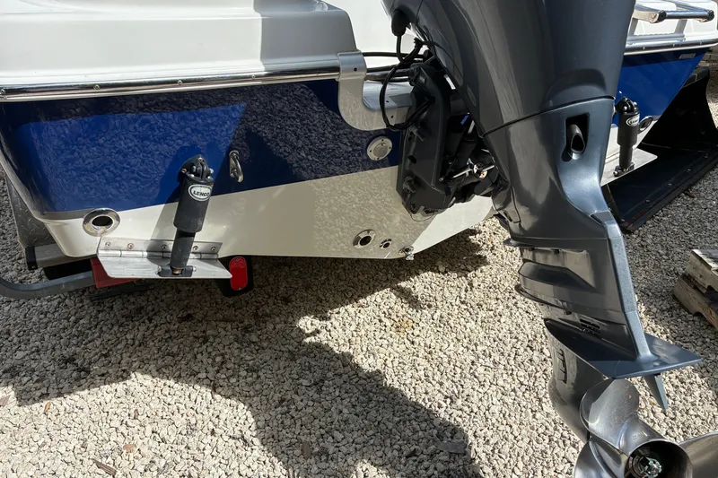 Slide: The Image of 2019 NauticStar 2102 Legacy boat with outboard motor on gravel surface. - 12