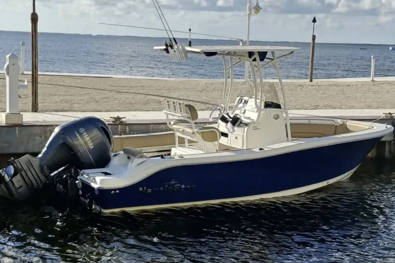 The Image of 2019 NauticStar 2102 Legacy boat docked by the beach with Yamaha engine. - 0