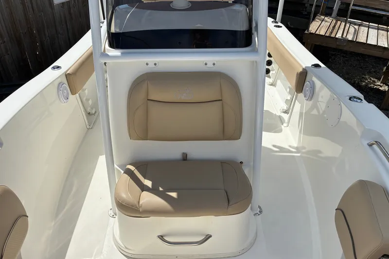 Slide: The Image of 2019 NauticStar 2102 Legacy boat interior with tan seating and white deck. - 7