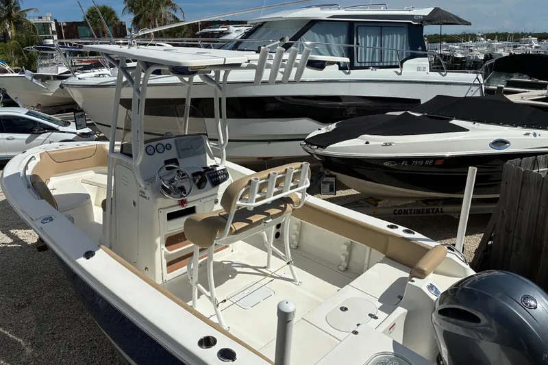 Slide: The Image of 2019 NauticStar 2102 Legacy boat docked, featuring a sleek design and modern console. - 2