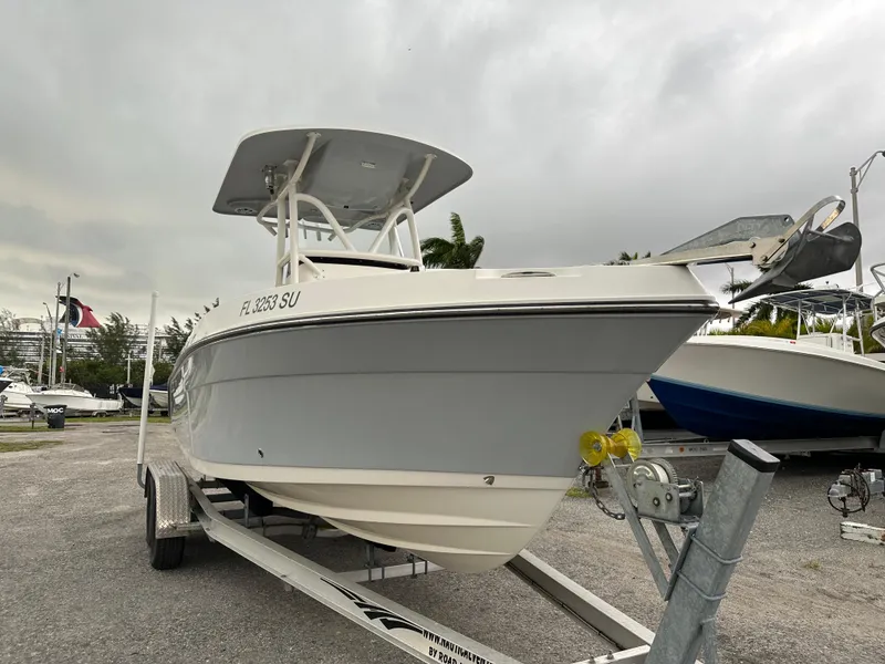 Slide: The Image of 2015 Century 2301 boat on trailer, parked outdoors under cloudy sky. - 10
