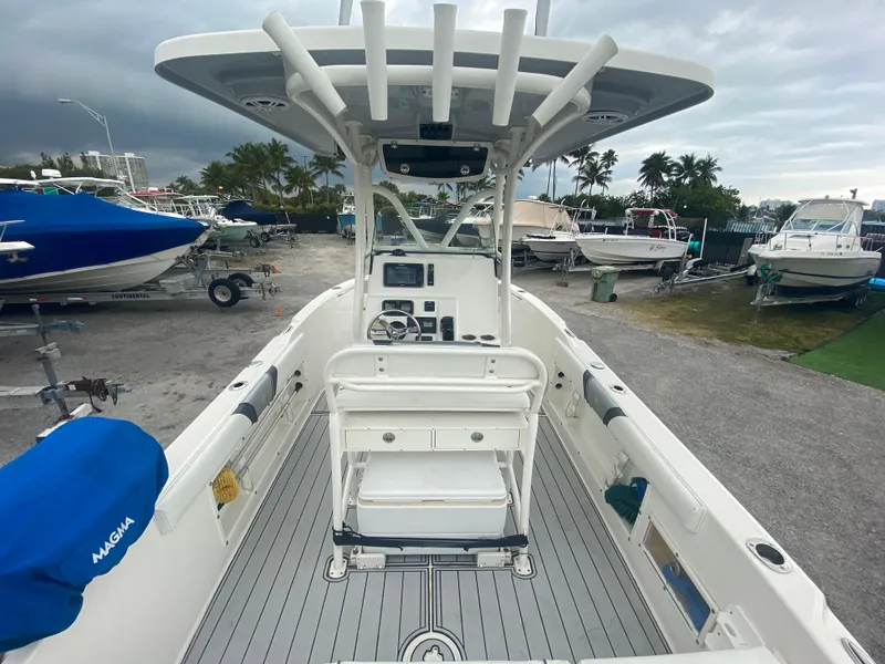 Slide: The Image of 2015 Century 2301 boat interior with helm, seating, and storage, docked in a marina. - 23