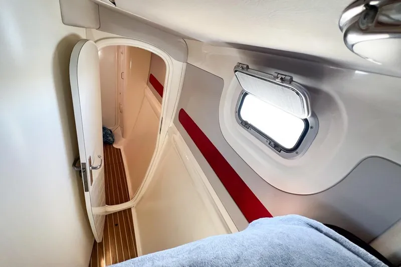 Slide: The Image of Interior of a 2000 Leopard 38 yacht cabin with porthole and wooden flooring. - 49