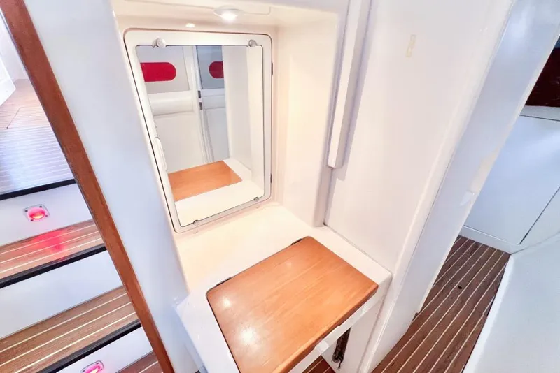 Slide: The Image of Vanity area on a 2000 Leopard 38 yacht with mirror and wooden surface. - 73