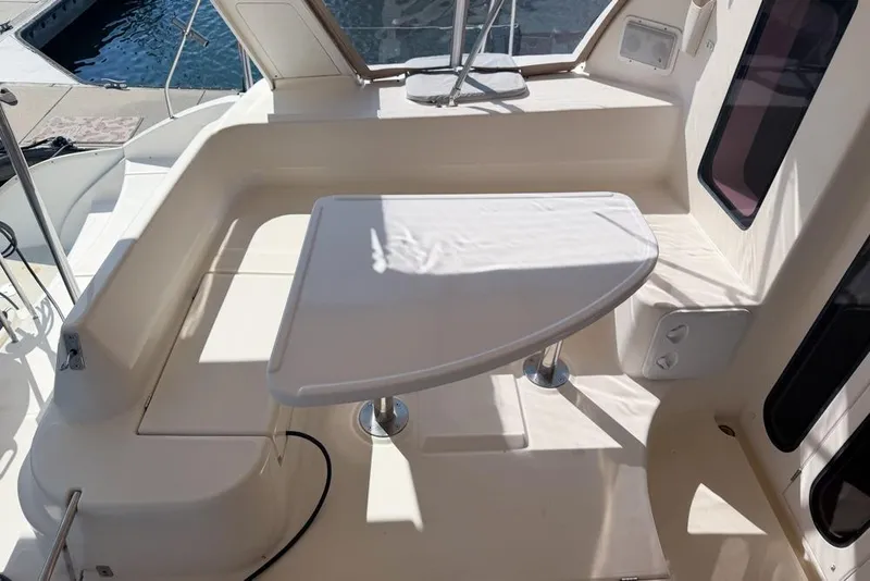 Slide: The Image of Leopard 38 catamaran cockpit with seating and table, 2000 model, docked by the water. - 90