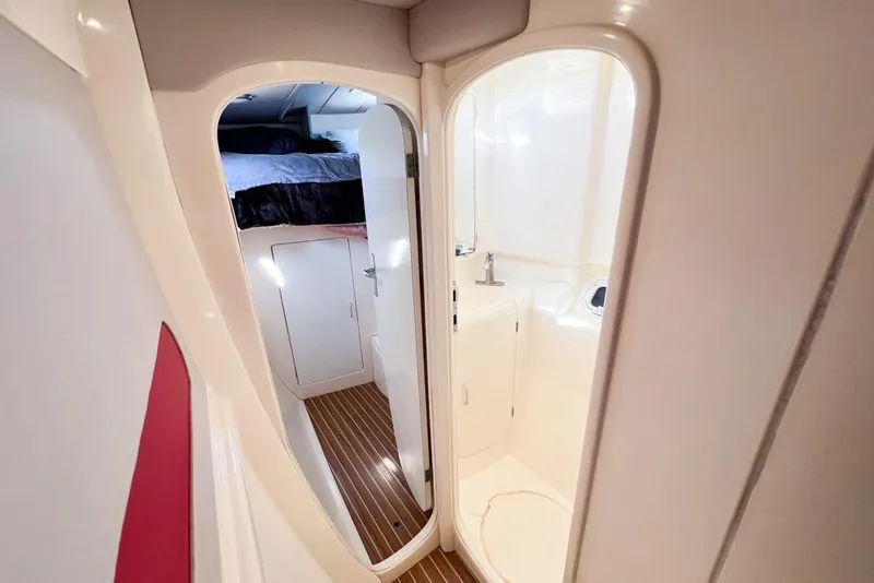 Slide: The Image of Interior of 2000 Leopard 38 yacht showing cabin and bathroom with wooden flooring. - 50