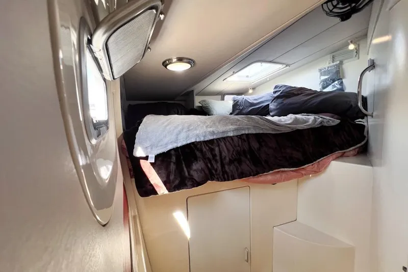 Slide: The Image of Cozy cabin interior of 2000 Leopard 38 catamaran with bed and porthole window. - 46
