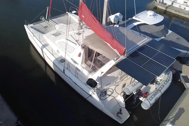 Slide: The Image of Catamaran Leopard 38, 2000 model, docked with solar panels and red sail. - 14