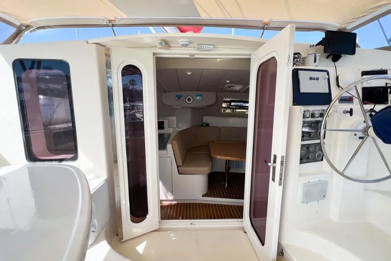 Slide: The Image of Interior view of a 2000 Leopard 38 catamaran, featuring a cozy seating area and helm. - 33