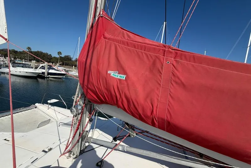 Slide: The Image of Red sail cover on Leopard 38 catamaran, docked in marina, clear blue sky. - 113