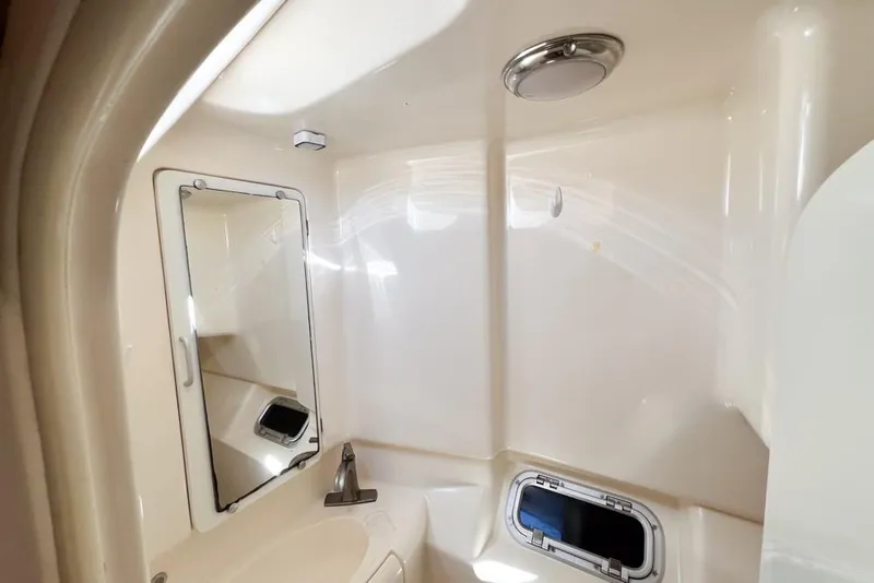 Slide: The Image of Compact bathroom in a 2000 Leopard 38 yacht, featuring a mirror and porthole. - 51