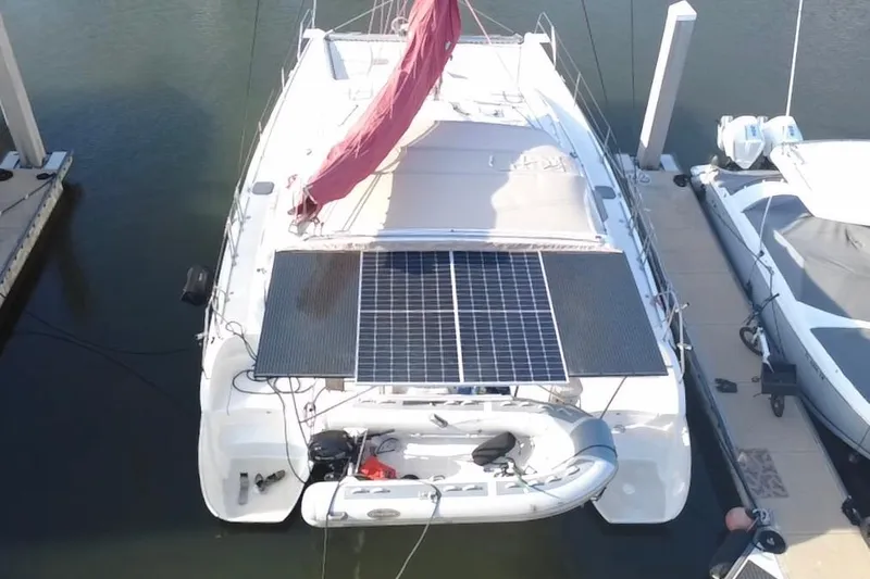 Slide: The Image of Aerial view of a 2000 Leopard 38 catamaran with solar panels and dinghy at dock. - 13