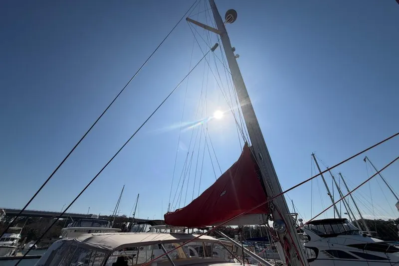 Slide: The Image of Sailboat mast with red sail under clear blue sky, Leopard 38, year 2000. - 103
