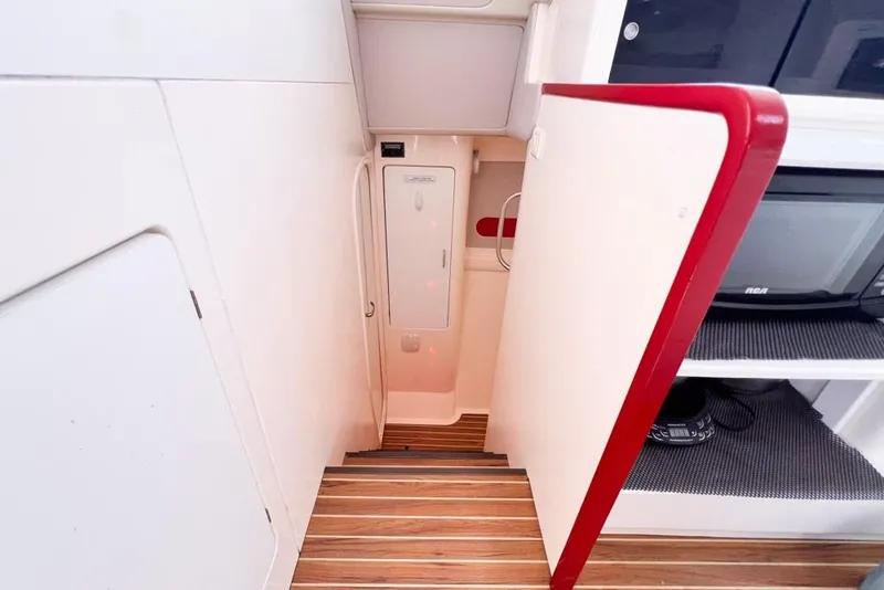 Slide: The Image of Narrow stairway inside a 2000 Leopard 38 yacht, featuring wooden steps and white cabinetry. - 44