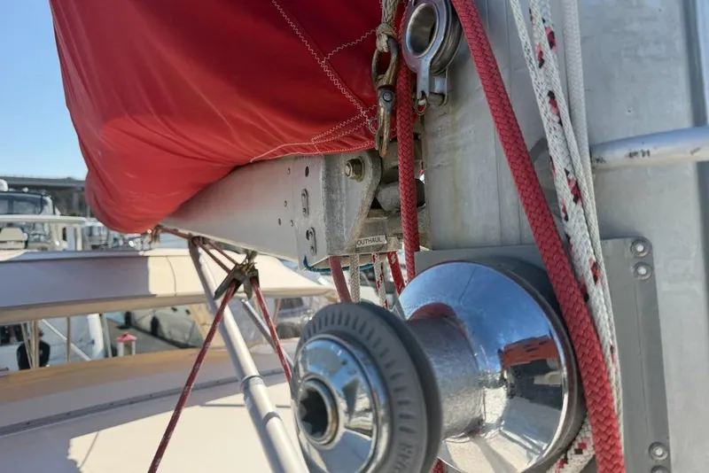 Slide: The Image of Close-up of a Leopard 38 sailboat's rigging and winch, featuring red sail cover. - 108