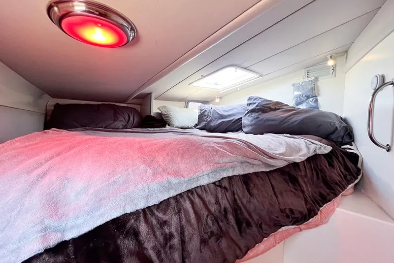 Slide: The Image of Cozy cabin bed in 2000 Leopard 38 yacht with red light and skylight. - 48