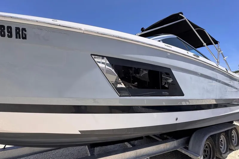 Slide: The Image of 2015 Four Winns H290 boat on trailer under clear blue sky. - 5