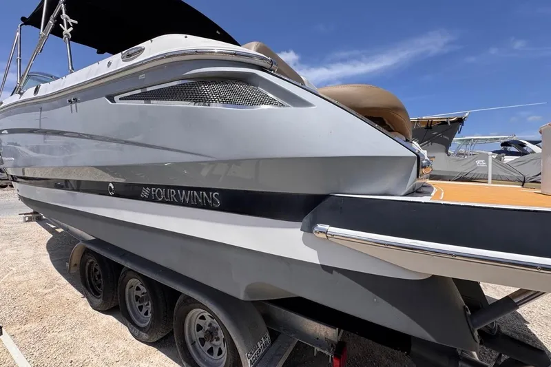 Slide: The Image of 2015 Four Winns H290 boat on trailer under clear blue sky. - 7