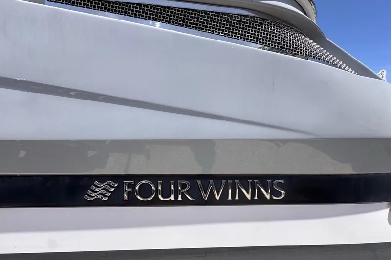 Slide: The Image of 2015 Four Winns H290 boat logo on white hull, showcasing brand emblem. - 8
