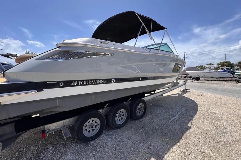 Slide: The Image of 2015 Four Winns H290 boat on trailer under clear blue sky. - 12