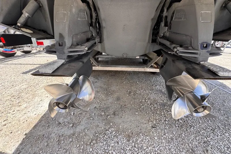 Slide: The Image of 2015 Four Winns H290 boat propellers and stern drive on gravel surface. - 19