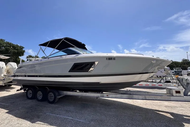 Slide: The Image of 2015 Four Winns H290 boat on trailer under clear blue sky. - 1
