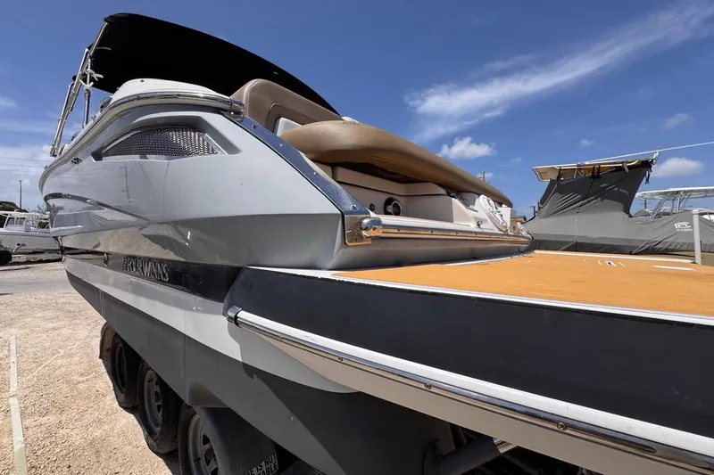Slide: The Image of 2015 Four Winns H290 boat with sleek design, docked under clear blue sky. - 20