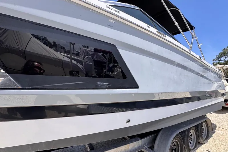 Slide: The Image of 2015 Four Winns H290 boat on trailer, side view under clear blue sky. - 6