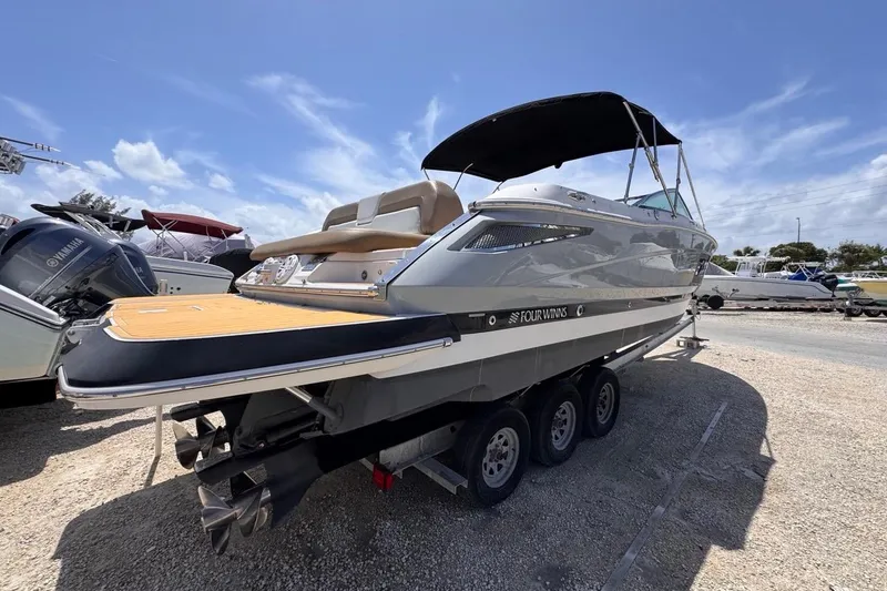 Slide: The Image of 2015 Four Winns H290 boat on trailer under clear blue sky. - 16