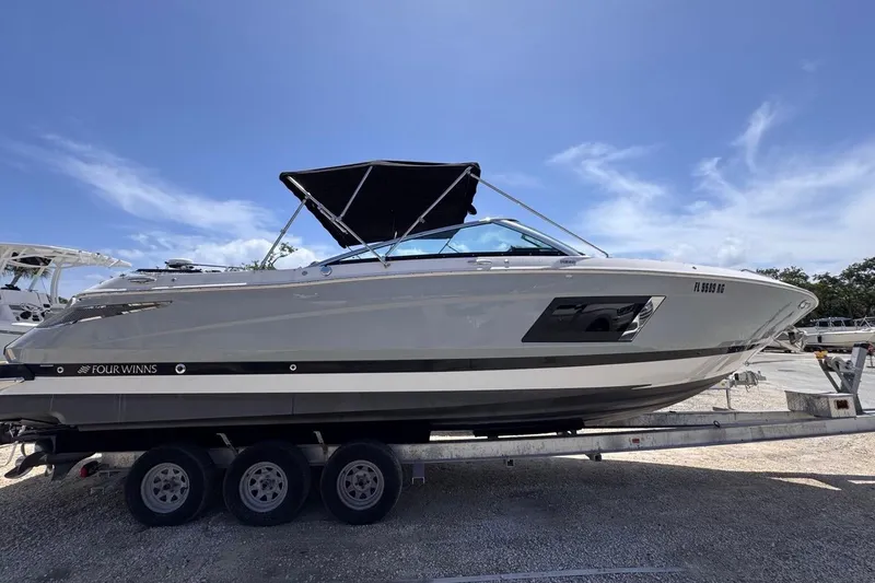 Slide: The Image of 2015 Four Winns H290 boat on trailer under clear blue sky. - 11