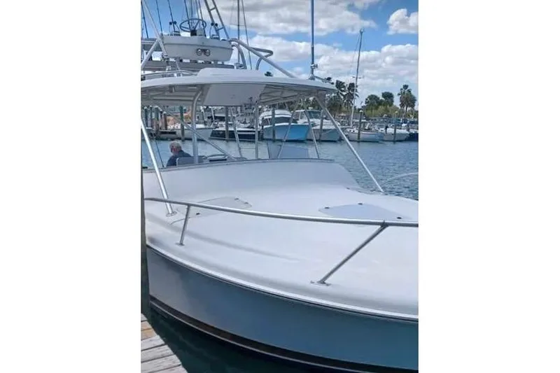 The Image of 2000 Luhrs Tournament 290 Open boat docked at marina under blue sky. - 1