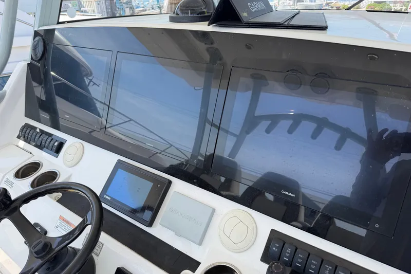 Slide: The Image of 2019 Regulator 41 boat dashboard with Garmin navigation displays and controls. - 31