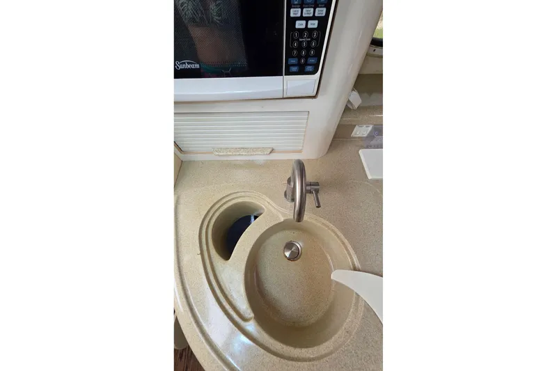 Slide: The Image of Compact kitchen area in a 2000 Monterey 330 Sport Yacht with sink and microwave. - 61