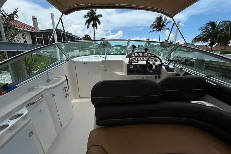 Slide: The Image of Cockpit of 2000 Monterey 330 Sport Yacht with steering wheel and dashboard, under clear skies. - 13