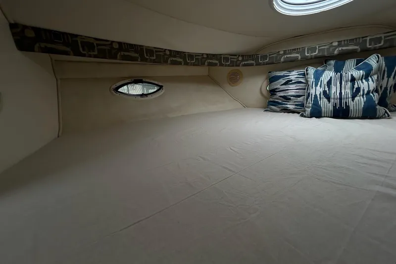Slide: The Image of Interior cabin of 2000 Monterey 330 Sport Yacht with decorative pillows and porthole window. - 47