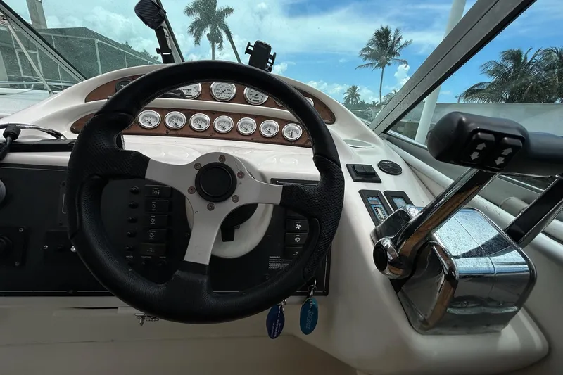 Slide: The Image of Steering wheel and controls of a 2000 Monterey 330 Sport Yacht, with gauges and palm trees visible. - 26