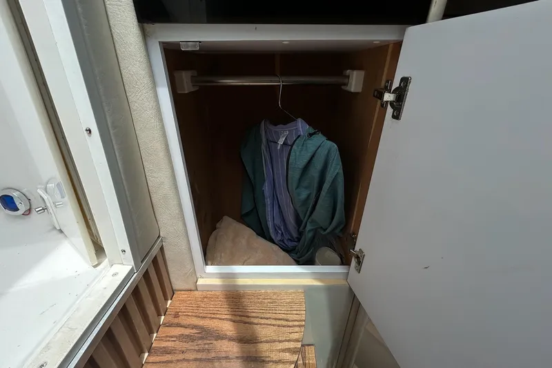 Slide: The Image of Small closet inside a 2000 Monterey 330 Sport Yacht with hanging clothes. - 44